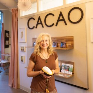 woman standing in from of CACAO Sign