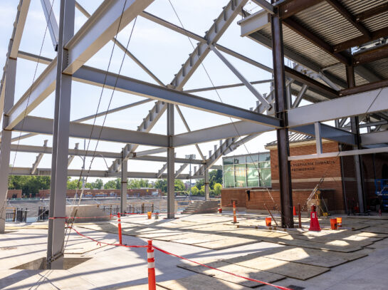 Interior Side Stadium Interior view of the Jerry Richardson Stadium expansion during construction, featuring exposed structural steel framing and unfinished floors for future premium hospitality spaces overlooking the football field.