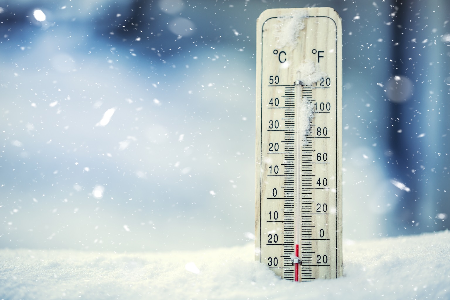 A thermometer in the snow registers below freezing temperatures. 