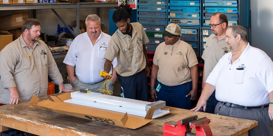 Kevin Gibbs and Tee Coleman, center, discuss new electrical equipment with their mentors and zone supervisors.