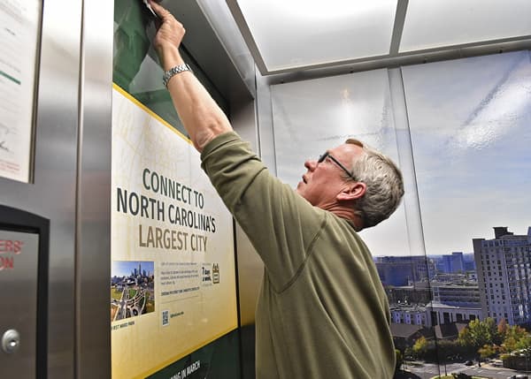 Workers install elevator wraps