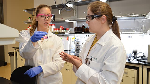 Keen, right, with Ph.D. student Kennedy-Neth working with a lab sample