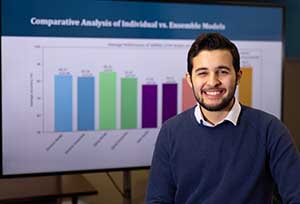 Mehdi Bourahla stands in front of chart