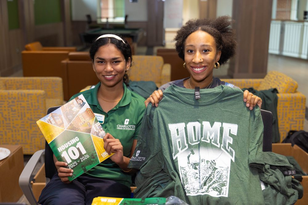 Housing and Residence Life staff show off housing packets and this year’s “Home” t-shirt