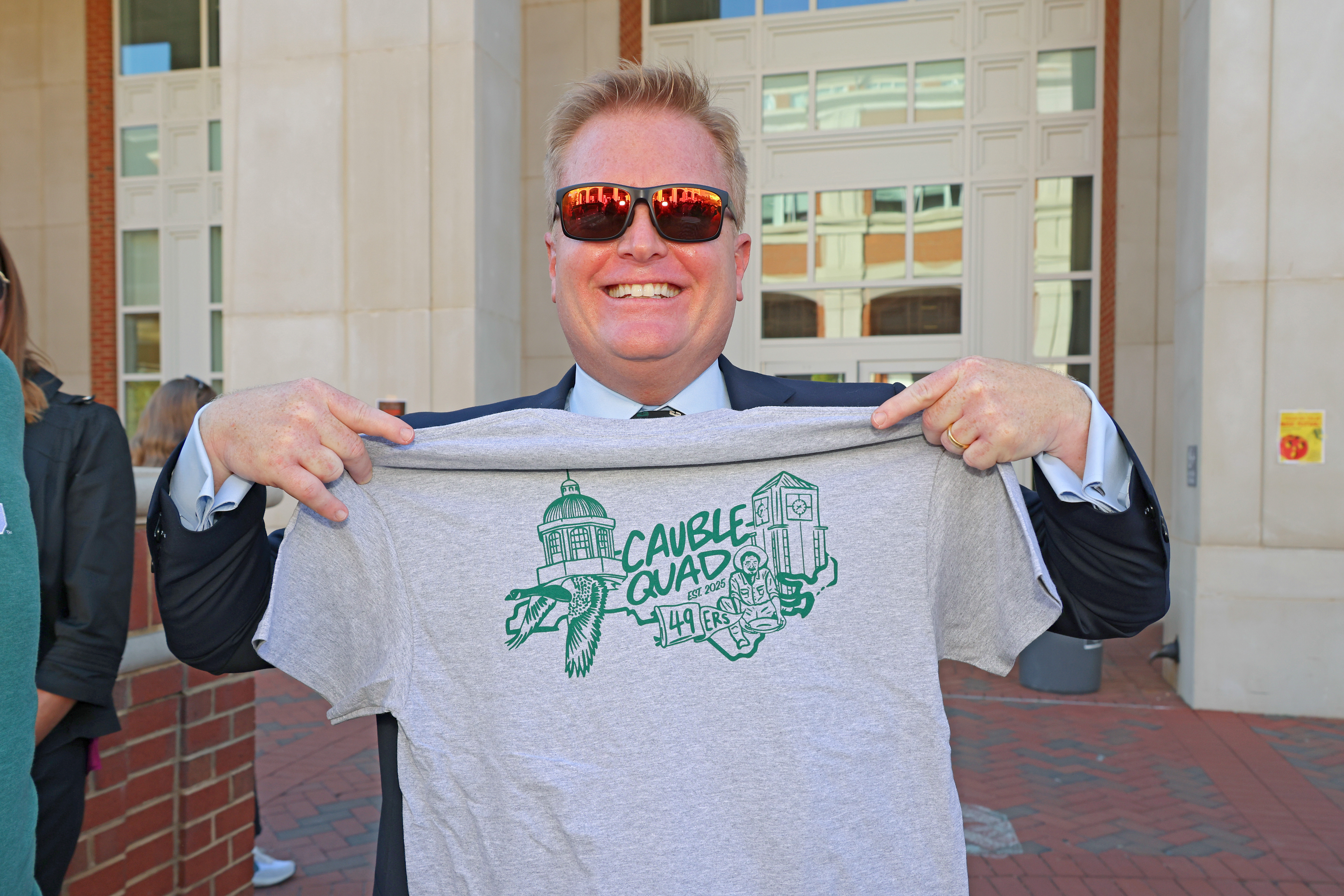Bo holds a commemorative t-shirt from the dedication of Cauble Quad.