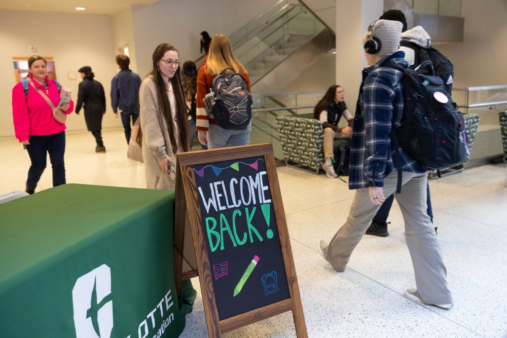Charlotte students walk past a "Welcome Back" sign on the first day of class