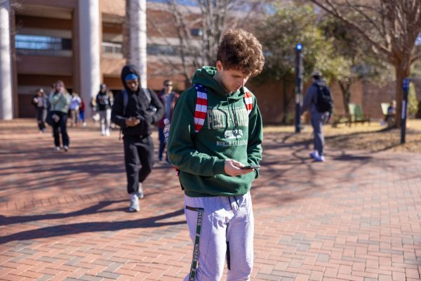 Student in a Forty-Niners hoodies looks down at phone on first day of class
