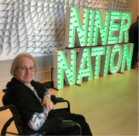 Christine Price in front of a Niner Nation Sign.