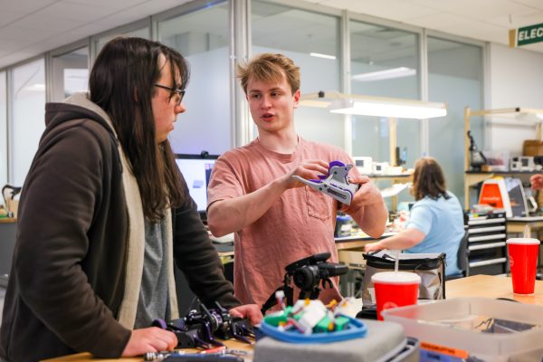 Brian Schoellner, a junior mechanical engineering major, holds Battle Bot design