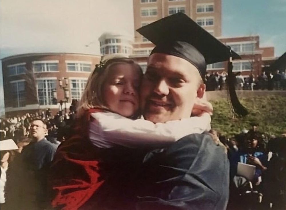 Five-year-old Madison hugs her father, Kenny, on his graduation day