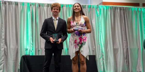 Two student athletes on stage at Normies Awards