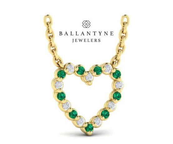 Gold heart-shaped pendant with green and clear stones on a gold chain, with the text 