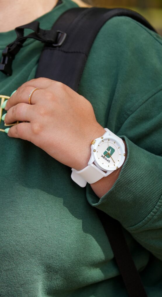 SPGBK-Watch-4 Close-up of a person wearing a white wristwatch featuring the UNC Charlotte All-in-C logo while holding a backpack strap.