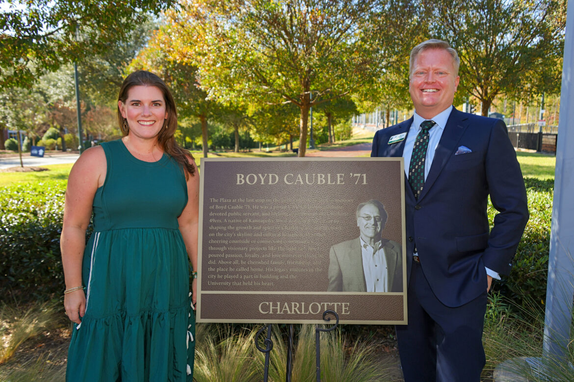 Bo and Angie Cauble stand in front of the plaque honoring Bo's dad, Boyd, near the light rail platform.