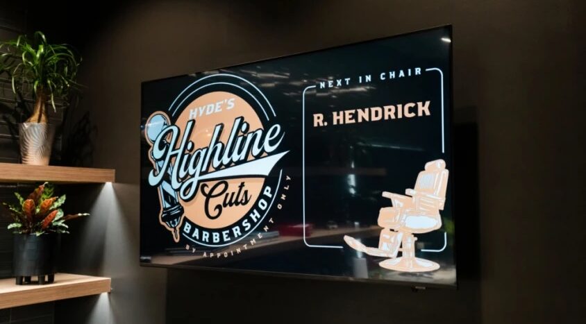 Digital display inside Hyde's Highline Cuts Barbershop showing the next appointment for R. Hendrick.