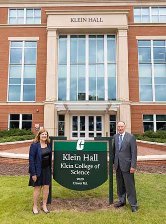 The Kleins with the sign in front of Klein College of Science