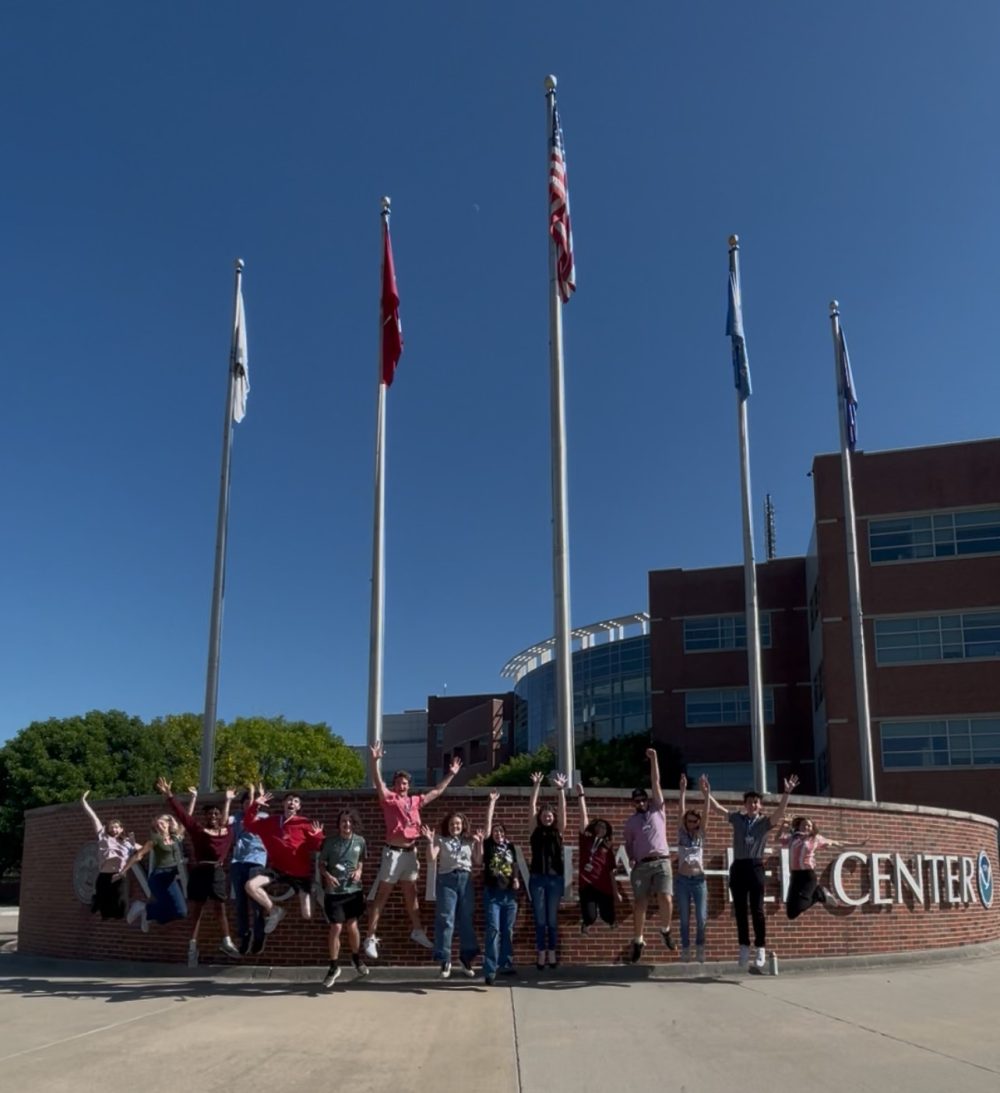 National Weather Center interns jumping outside of main entrance