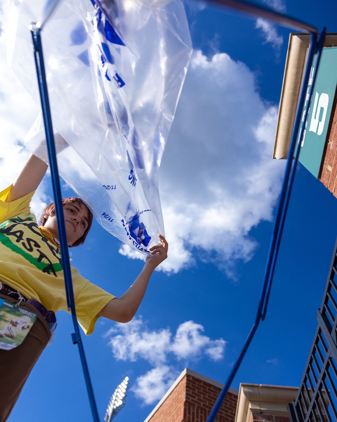 ZeroWaste_BinsSetup_Vertical Zero-waste steward sets up recycling bin