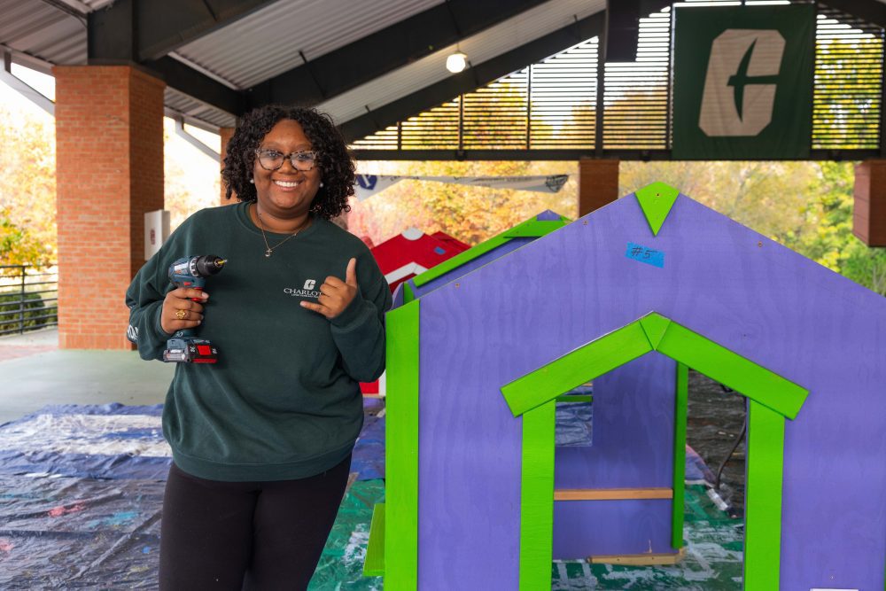Levine Scholar poses by playhouse