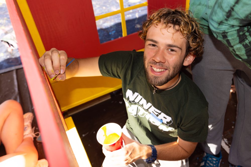 Levine Scholar paints inside of a playhouse