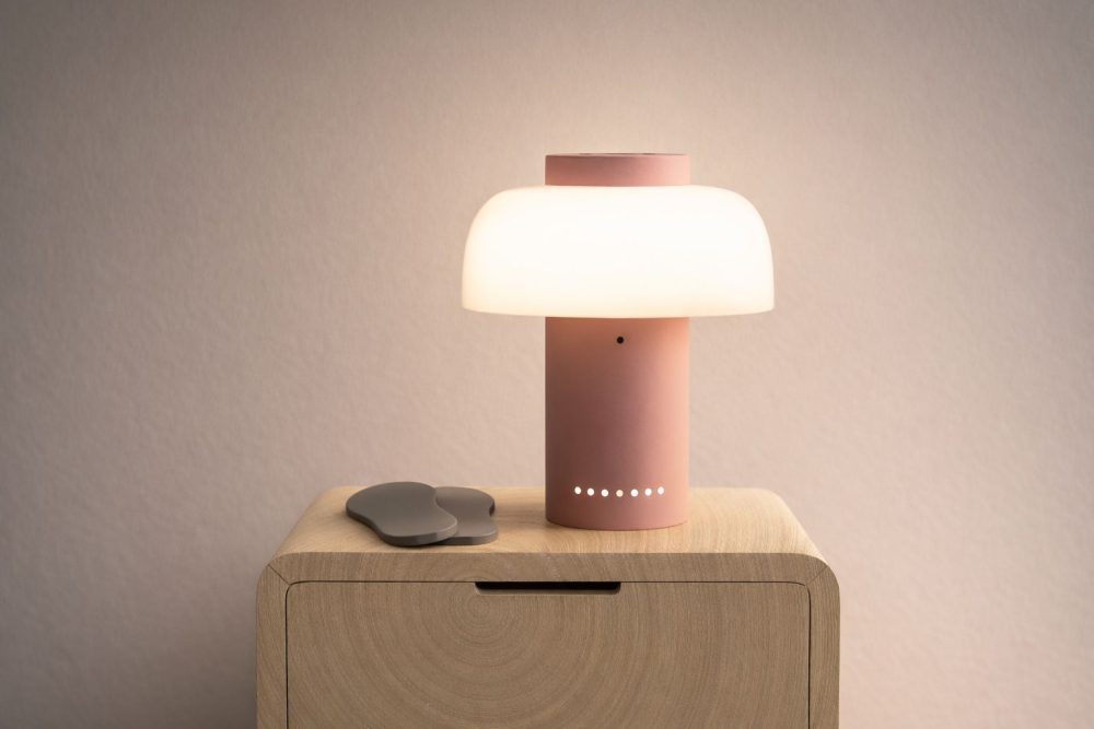 Neevel hub sits on a bedside table next to sensor-equipped insoles