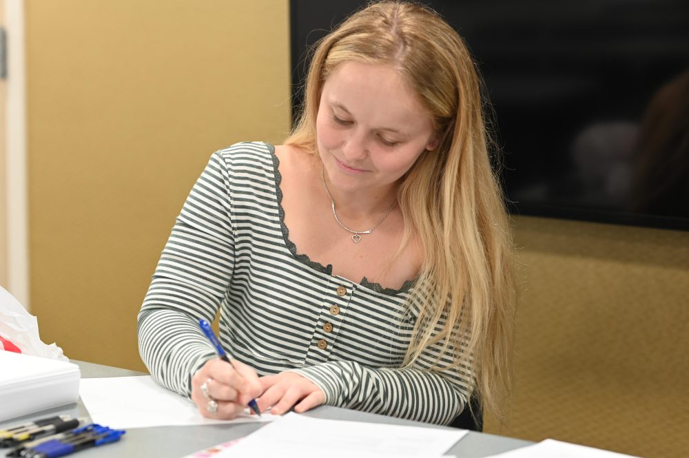 Gracie Bricker writing a letter to incarcerated women