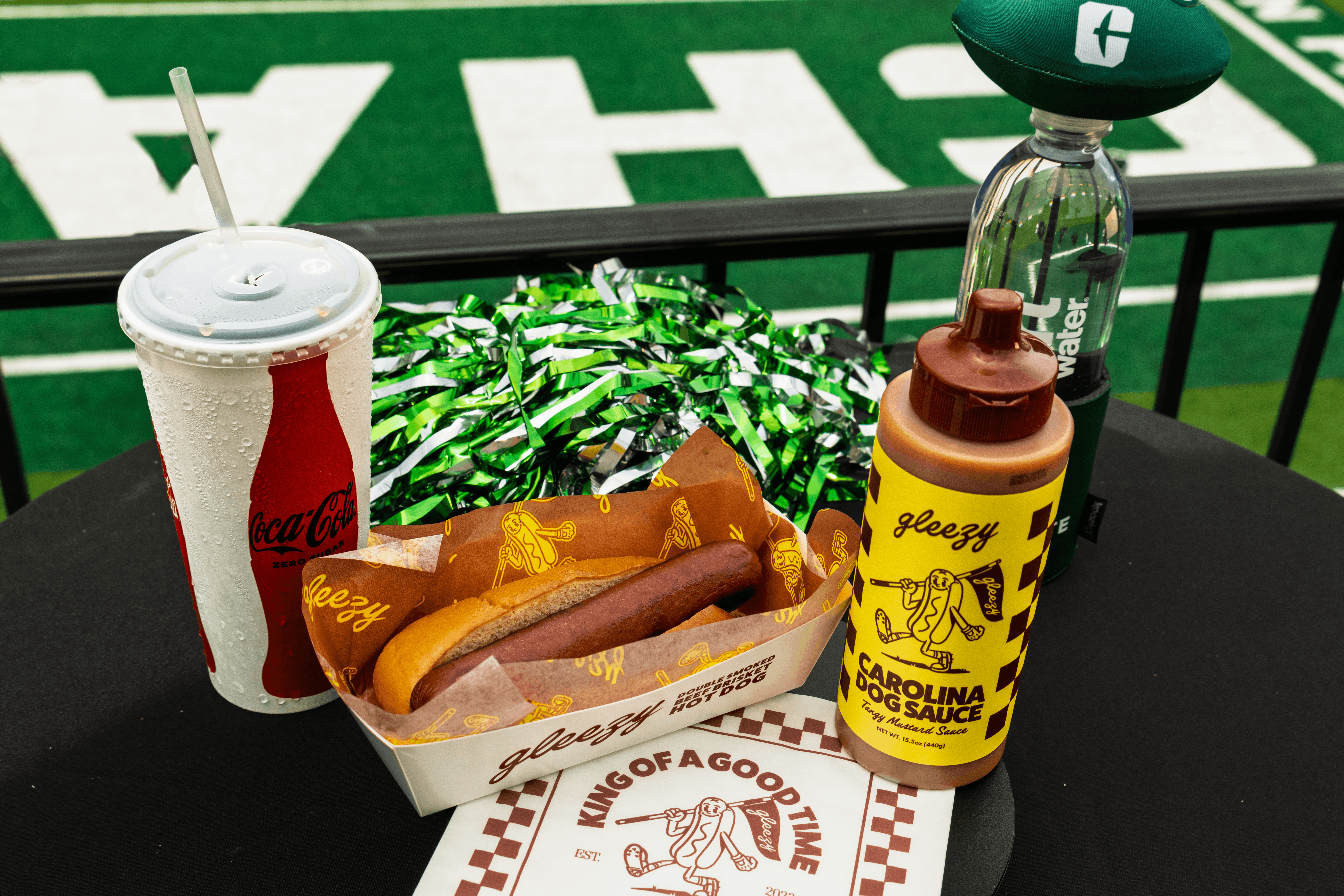 08122026FootballConcessionsMenuItems410 (1) Gleezy Dog Carolina Dog Sauce, and hot dogs on display at Jerry Richardson food showcase.