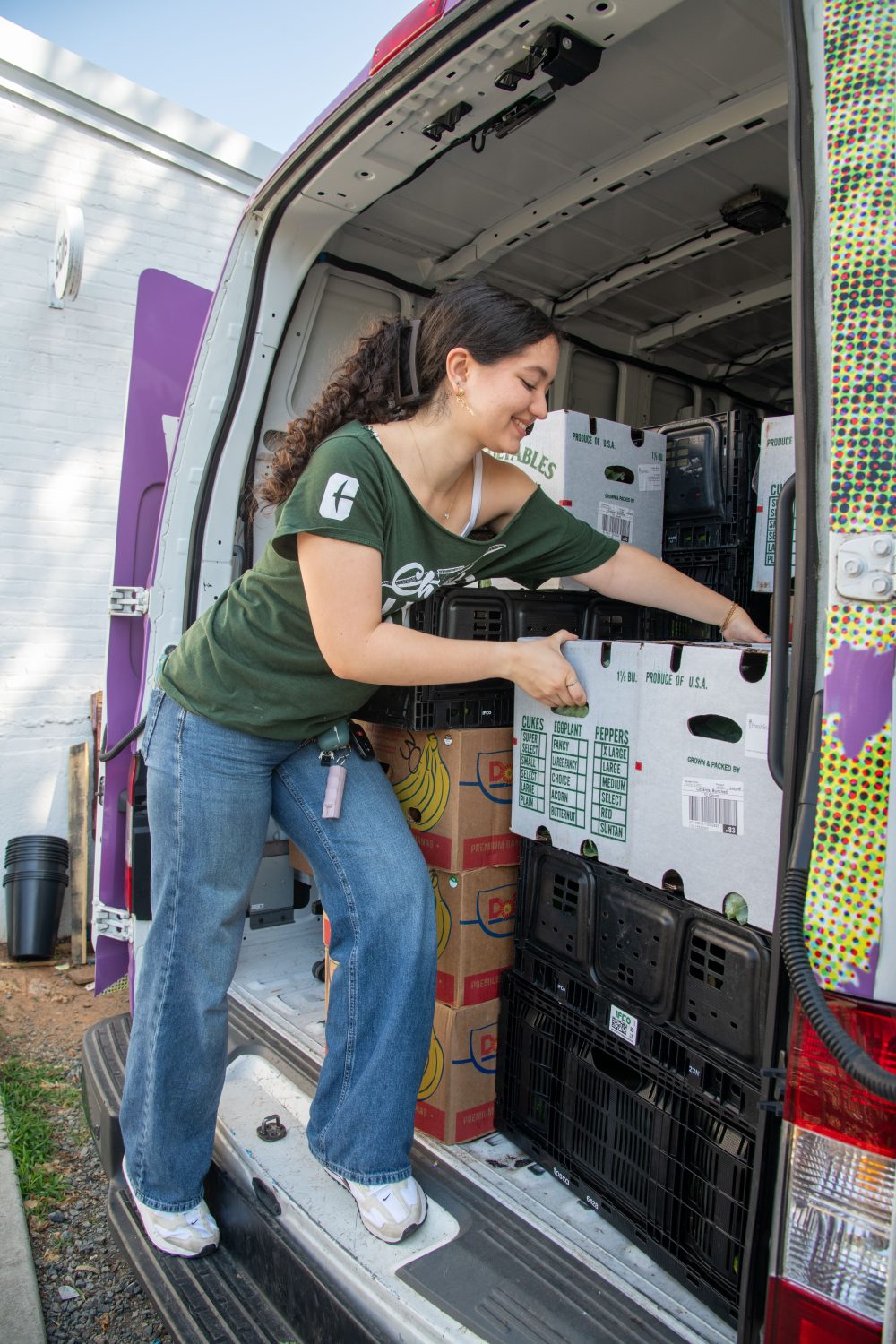 Thalia Dominguez Martinez takes a box of reclaimed food from the Bulb truck.
