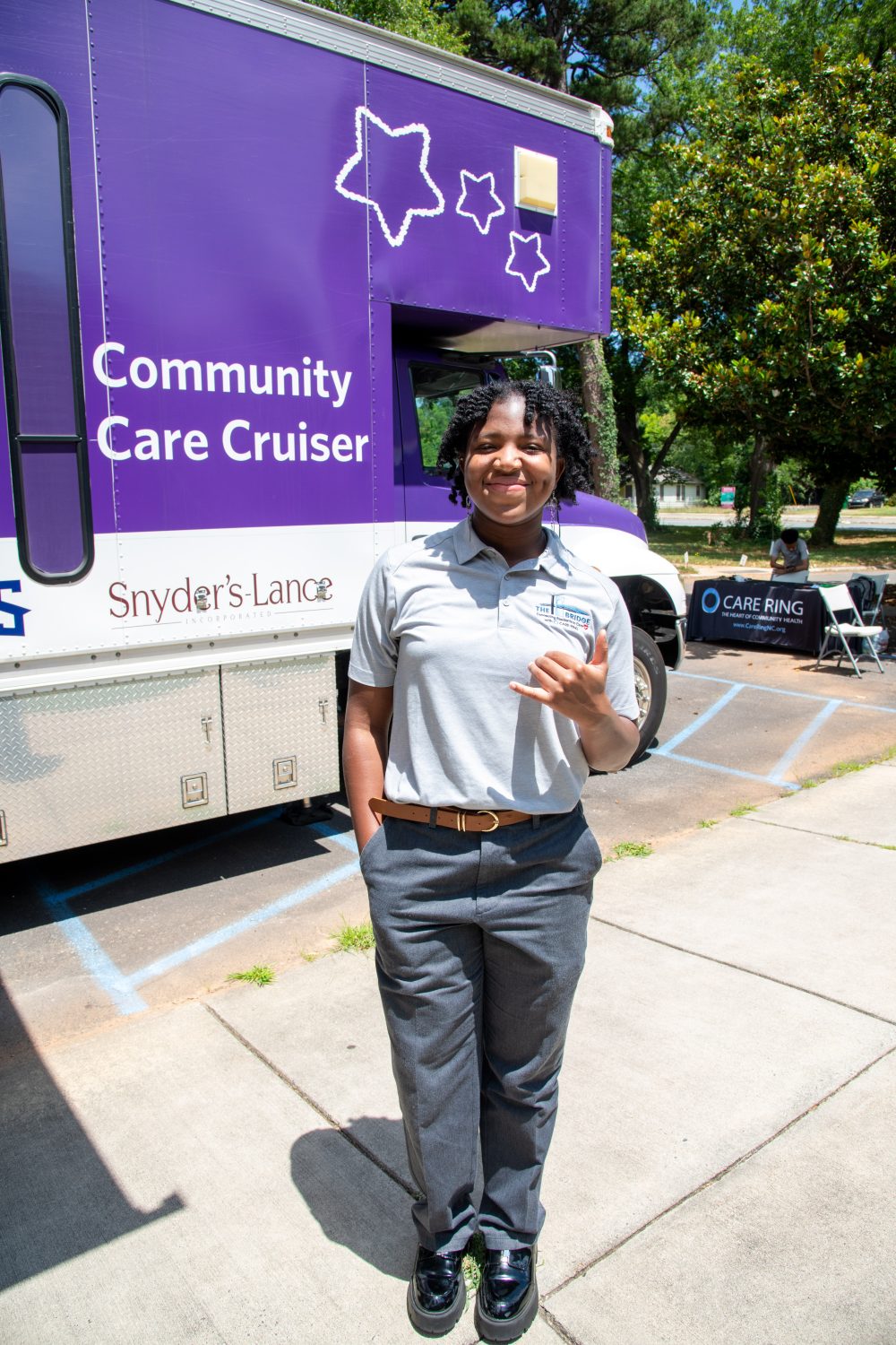Hannah Holness throws picks up in front of Care Ring community care cruiser