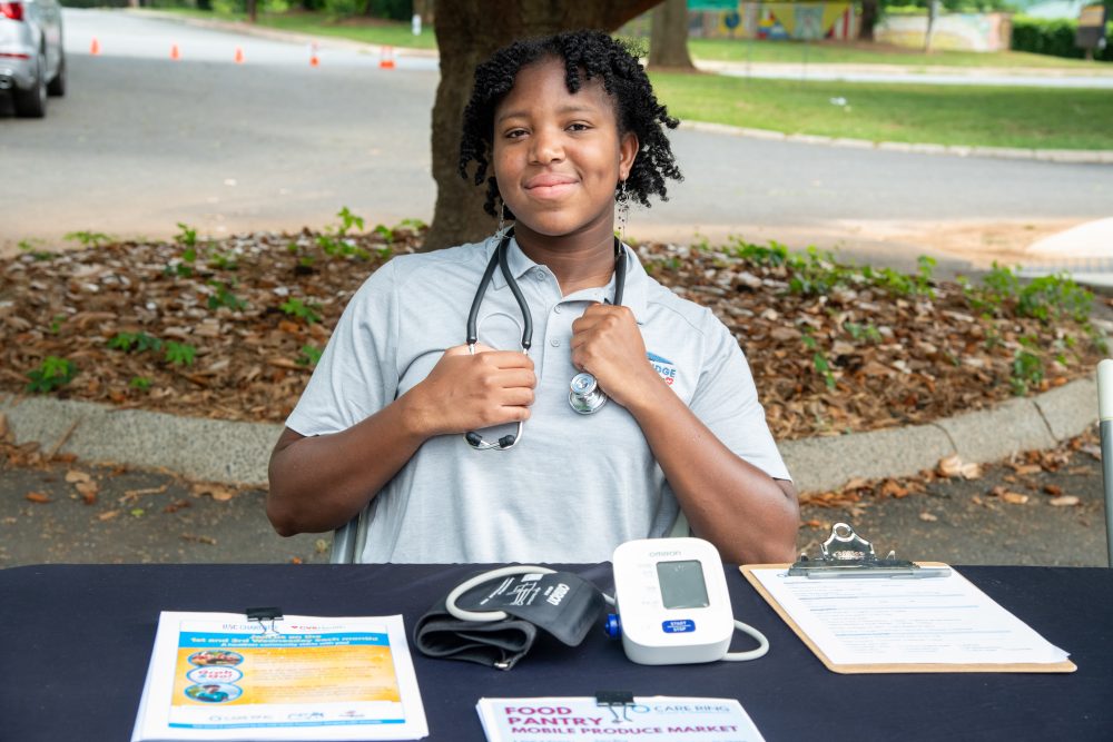 Hannah Holness wears stethoscope around her neck at Care Ring mobile clinic