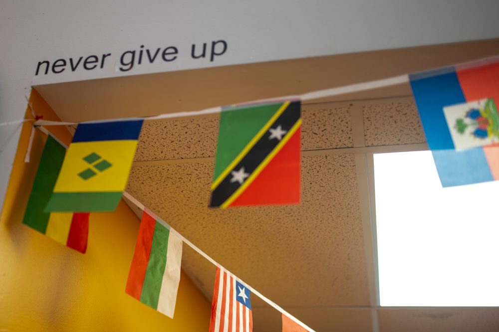 Flags of the world and the words "never give up" on the wall at ourBRIDGE for KIDS