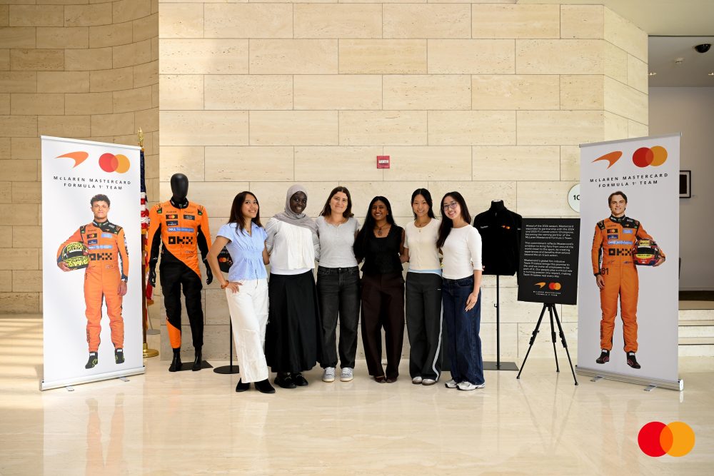 Faty Mbaye stands with a cohort by a Mastercard-NASCAR pop-ip