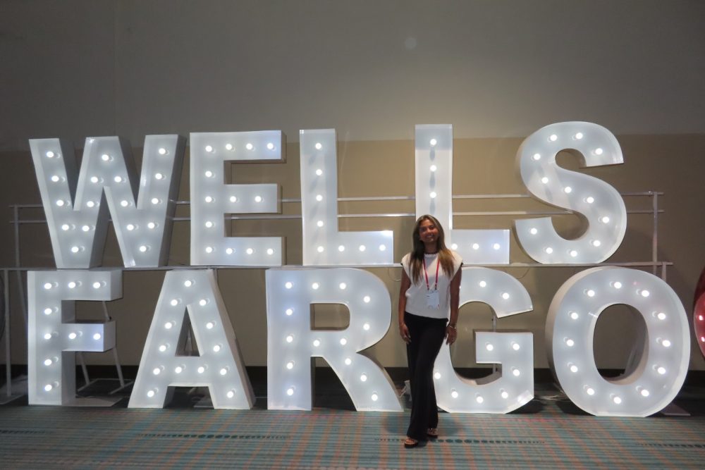 Nia Patel stands in front of the Wells Fargo sign