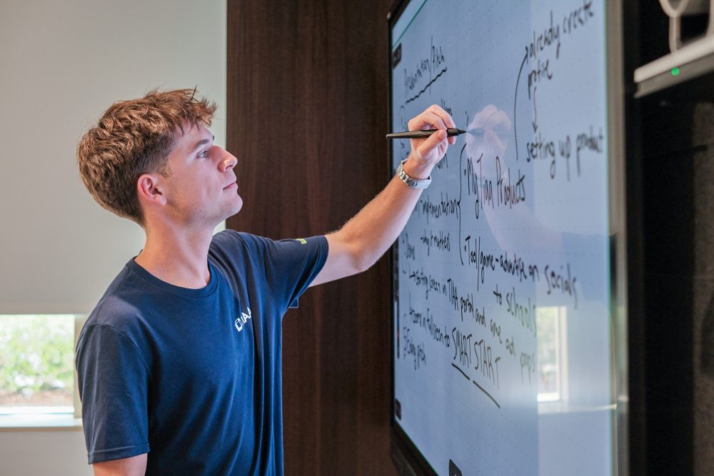 Owen Hardig, an intern at TIAA, draws on a whiteboard