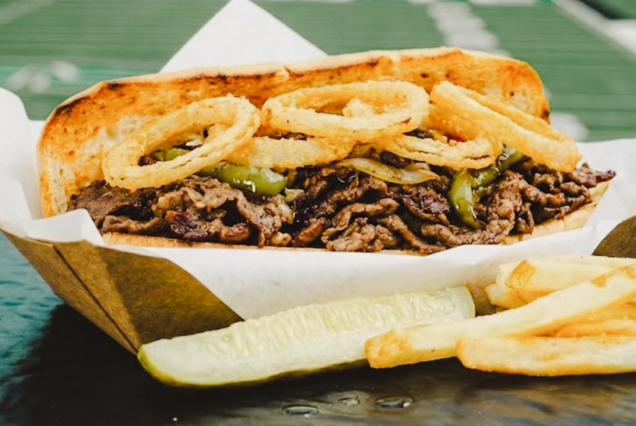 The Albinator (Crop) The Albinator Sandwich is loaded with Ribeye, provolone, roasted peppers and onions and topped with crispy onion petals.