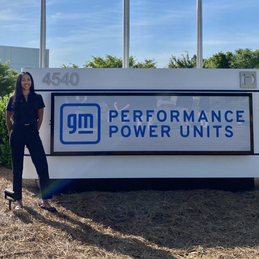 Kameran Blake stands in front of the GM Performance Power Units sign