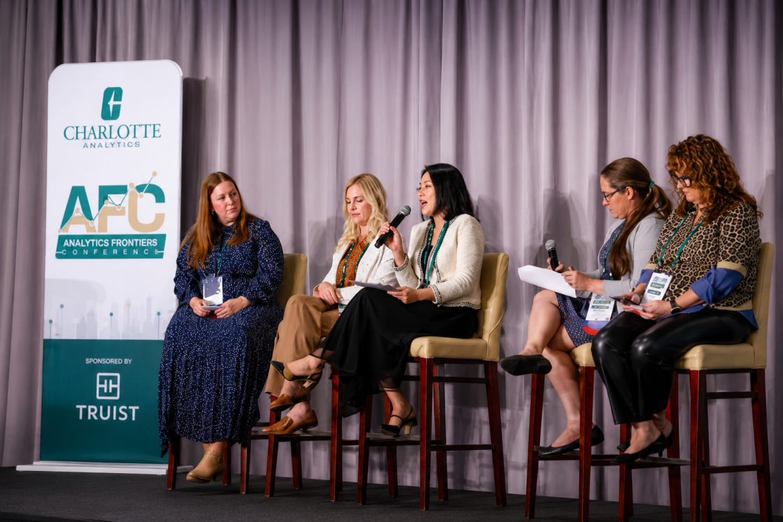 2026 Truist Report - AFC Five panelists participate in a discussion at the Charlotte Analytics Analytics Frontiers Conference, seated on stage with microphones beside a conference banner sponsored by Truist.