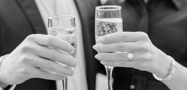 Two people holding champagne flutes in a celebratory toast.