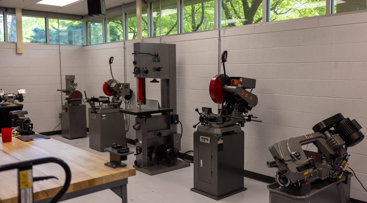 Wide view of a university machine shop with various tools, equipment, and workstations.