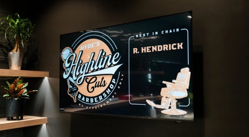 Digital display inside Hyde's Highline Cuts Barbershop showing the next appointment for R. Hendrick.